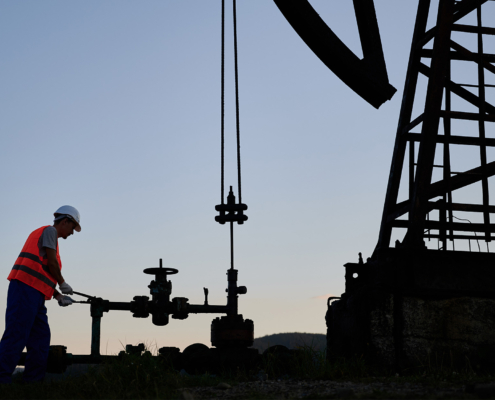 Petroleum operator in work vest using oil pump rocker-machine