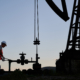 Petroleum operator in work vest using oil pump rocker-machine